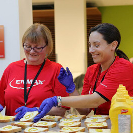 Enmax employees smile while volunteering to make sandwiches for Calgarians in need.