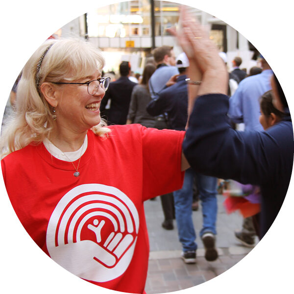 An United Way employee gives out high fives.