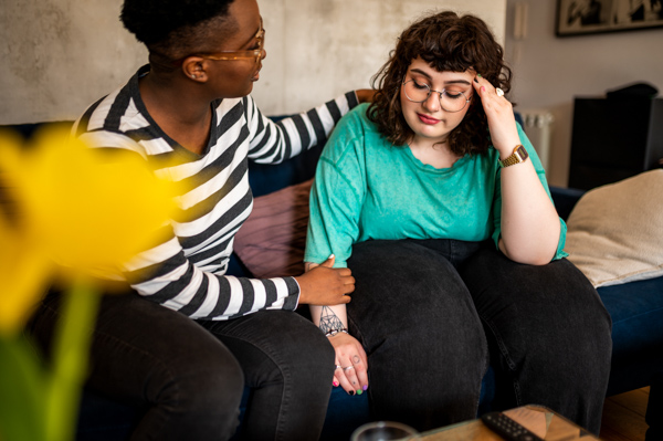 A woman consoles another woman