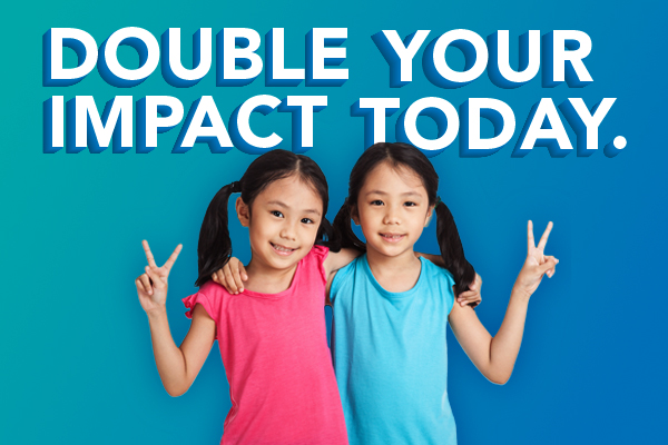 Twins hold up peace signs, text reads, `` Double your impact today.``
