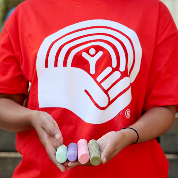 A woman in a United Way t-shirt holds chalk